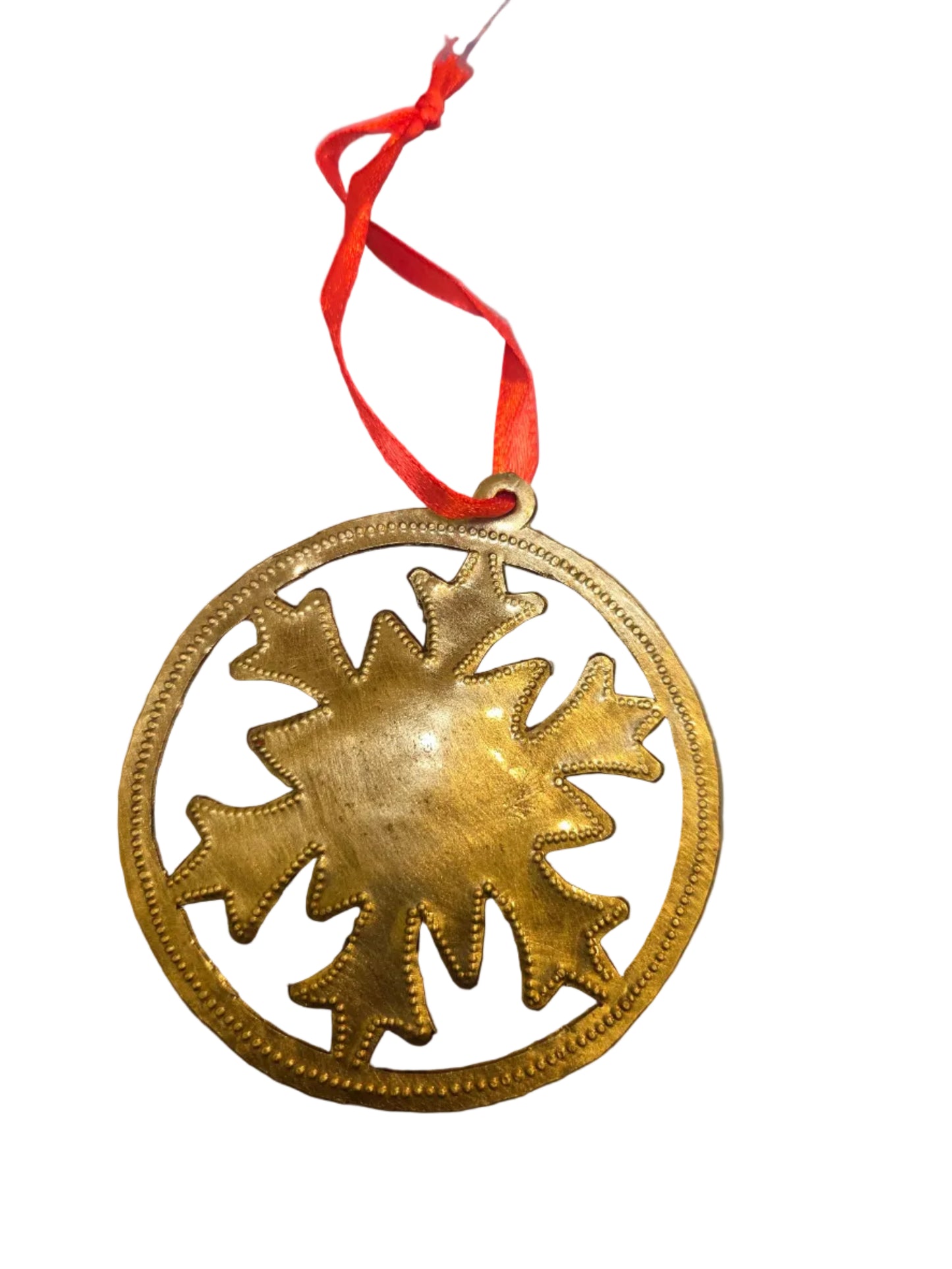 Decorative gold sun-shaped ornament with a red string on a white background